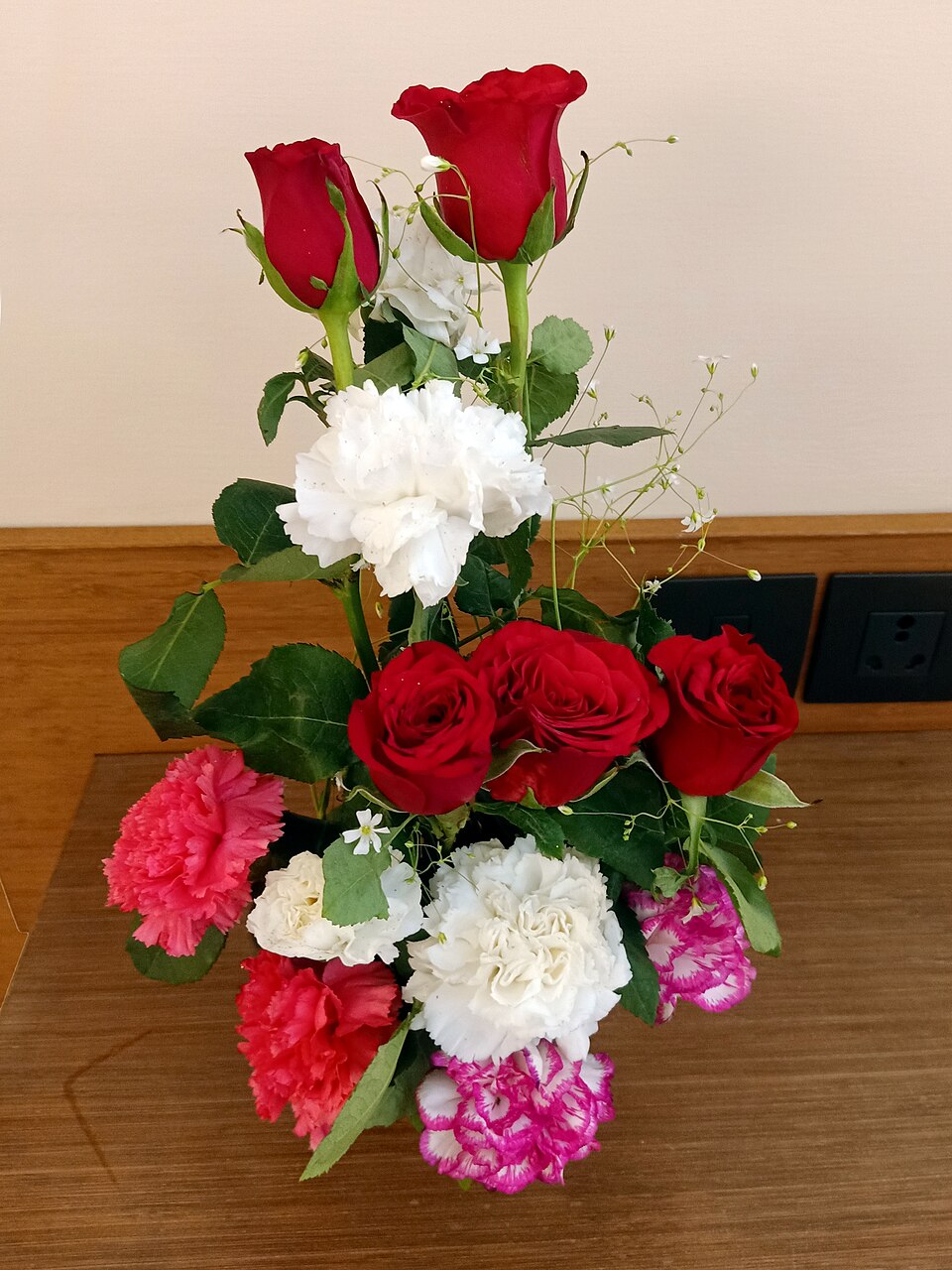 Composition de roses rouges et d'œillets